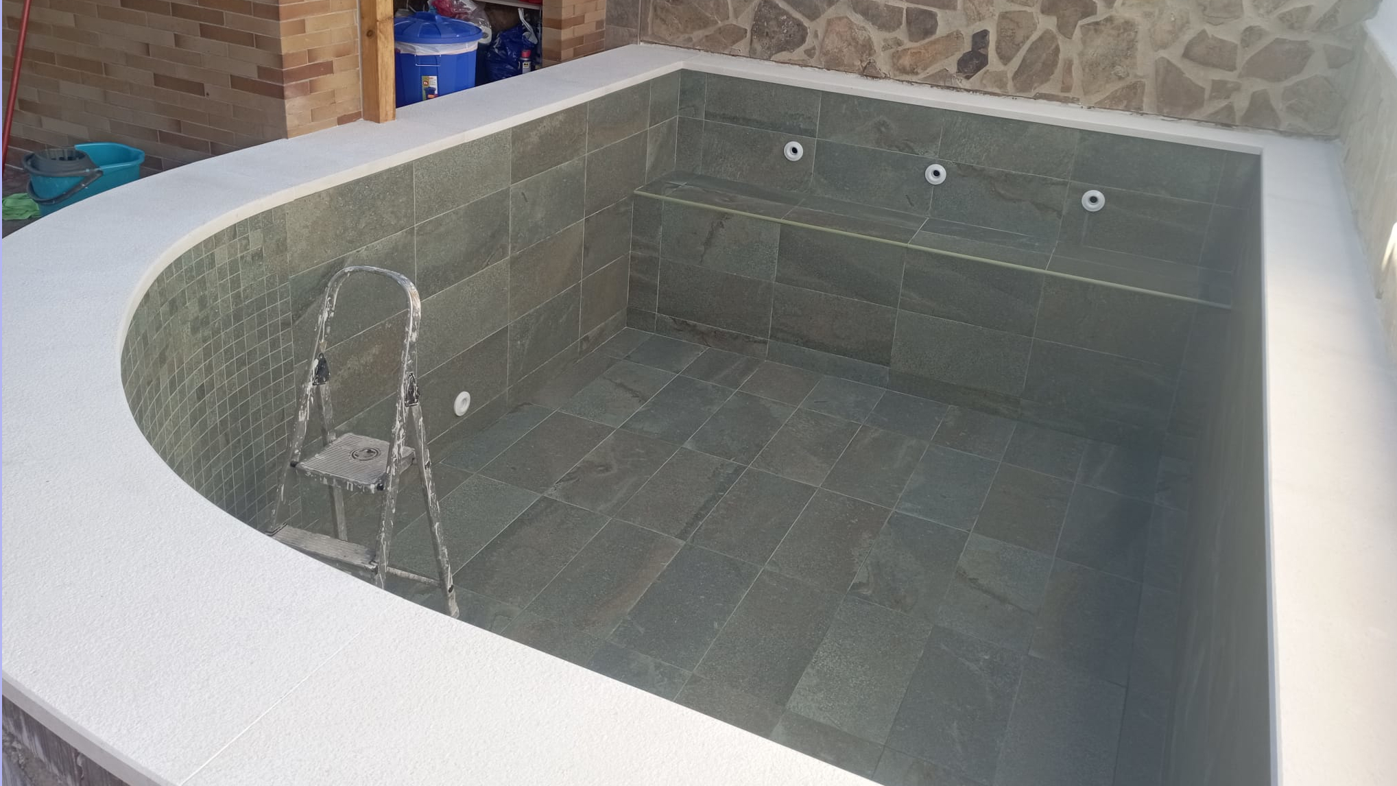 Colocación de azulejos y chorros en la piscina